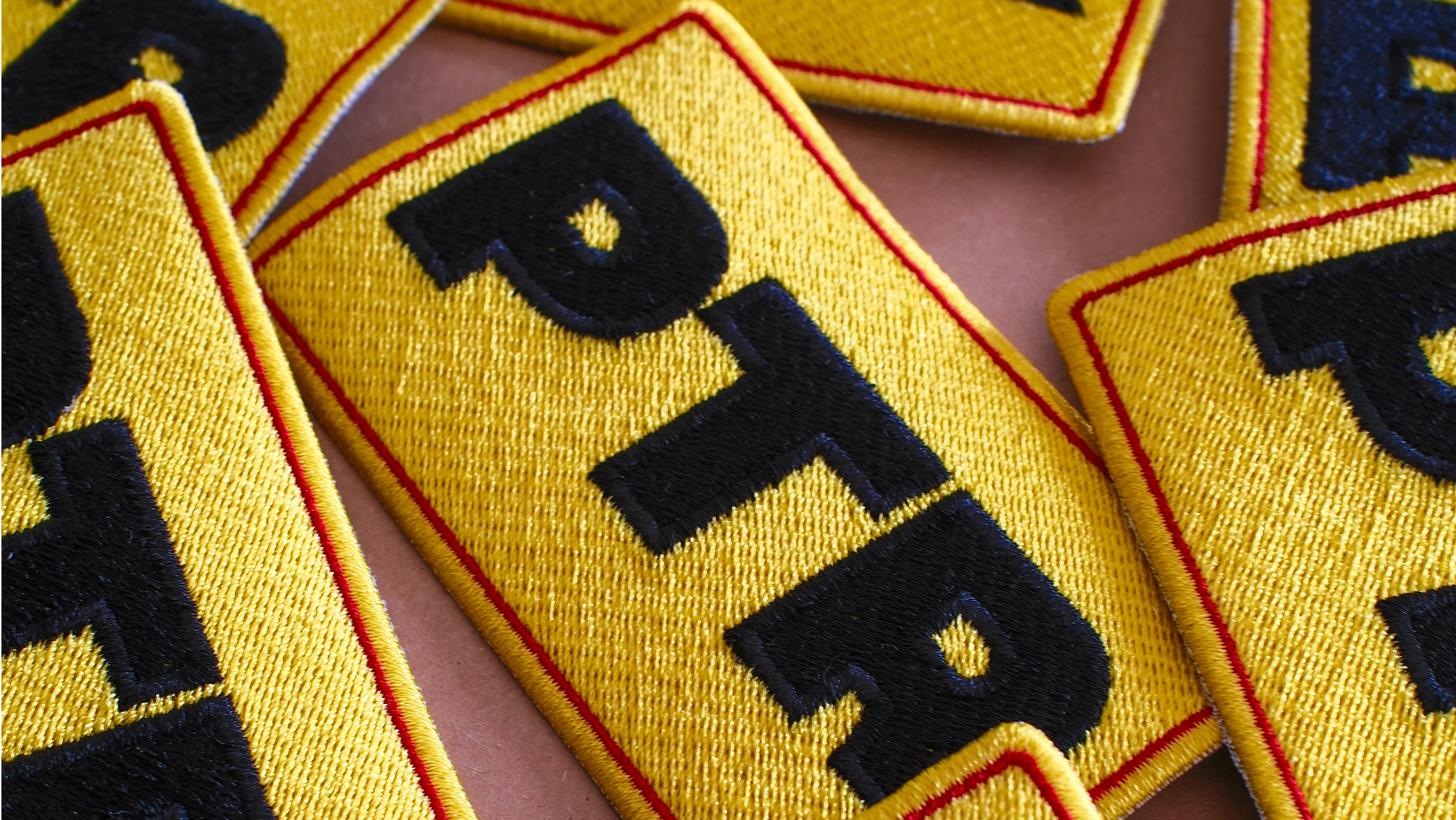 Embleme brodate personalizate pentru uniforme industriale realizate de NIUA Labs pentru PTR Solutions S.R.L.